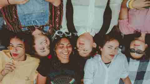 A photo of a group of young women lying head to head, facing opposite directions.