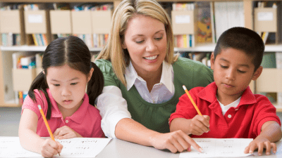 Teacher helping two students at the beginning of the new school year